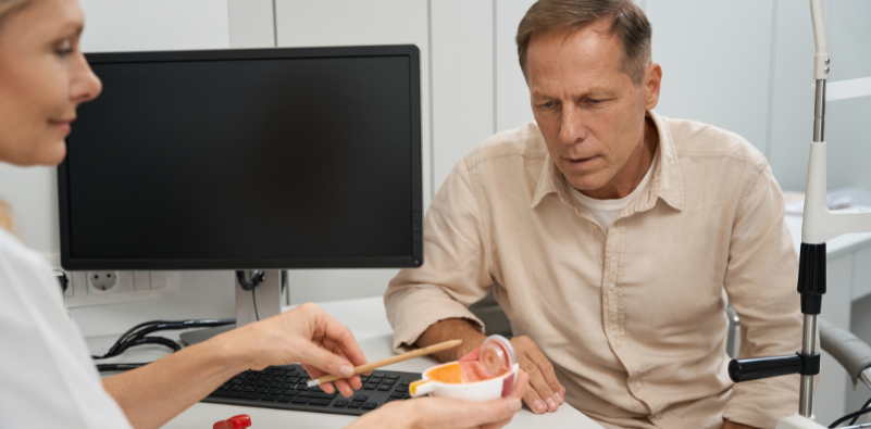 Female optician talking with male patient in office